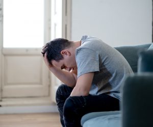 Man hunches over as he runs his hands through his hair. This image represents anxious thoughts of someone struggling with adhd and anxiety in Columbus, OH. Focused Mind ADHD Counseling offers relief for ADHD symptoms and support for adult ADHD and anxiety in Columbus, OH. Contact an adult adhd therapist today. 