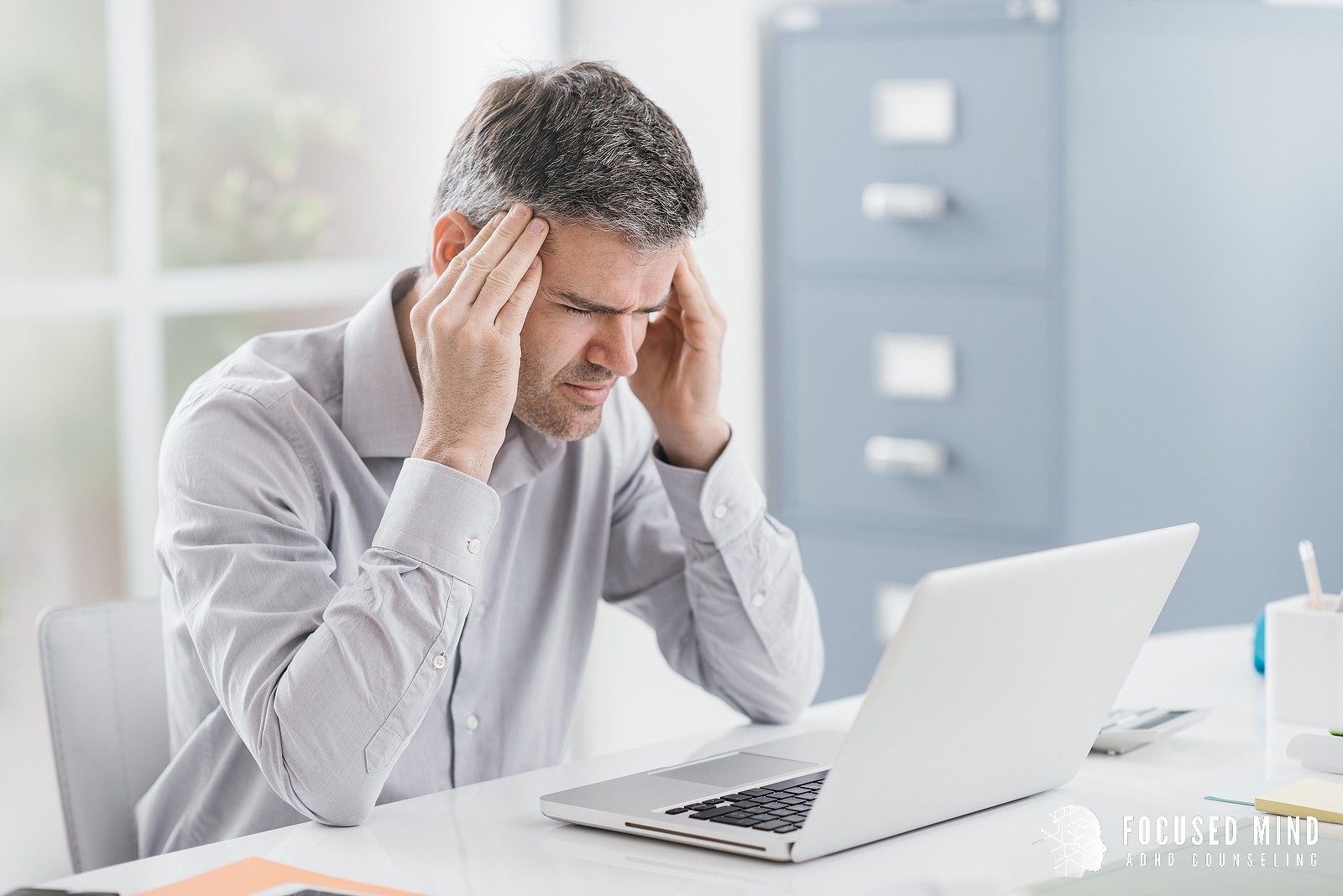 A man massages his temples as he looks at his computer screen. This represents the pain of ADHD thought loops. Learn more about ADHD symptoms and how ADHD and overthinking are linked. Focused Mind ADHD Counseling can offer support with anxiety therapy in Columbus, OH and more. 43017 | 43016 | 43214