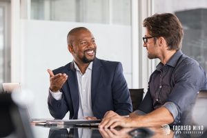 A businessman smiles at a co-worker as they talk at a table. This could represent the benefits of adult ADHD treatment in Columbus, OH. Learn more about Focused Mind ADHD Counseling by contacting an adult ADHD specialist in Ohio today! 43017 | 43016 | 43235 