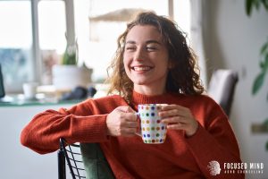 A woman smiles while holding a cup of coffee. This could symbolize the benefits of ADHD testing in Columbus, OH. Learn more about ADHD testing in Columbus Ohio by searching for “adhd testing columbus ohio adults” today.
