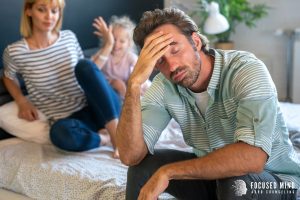 A father holds their head while their wife and daughter sit behind him. This could represent the stress of working on relationships. Learn more about ADHD and relationships by contacting an adult ADHD therapist in Ohio for ADHD treatment for adults. 