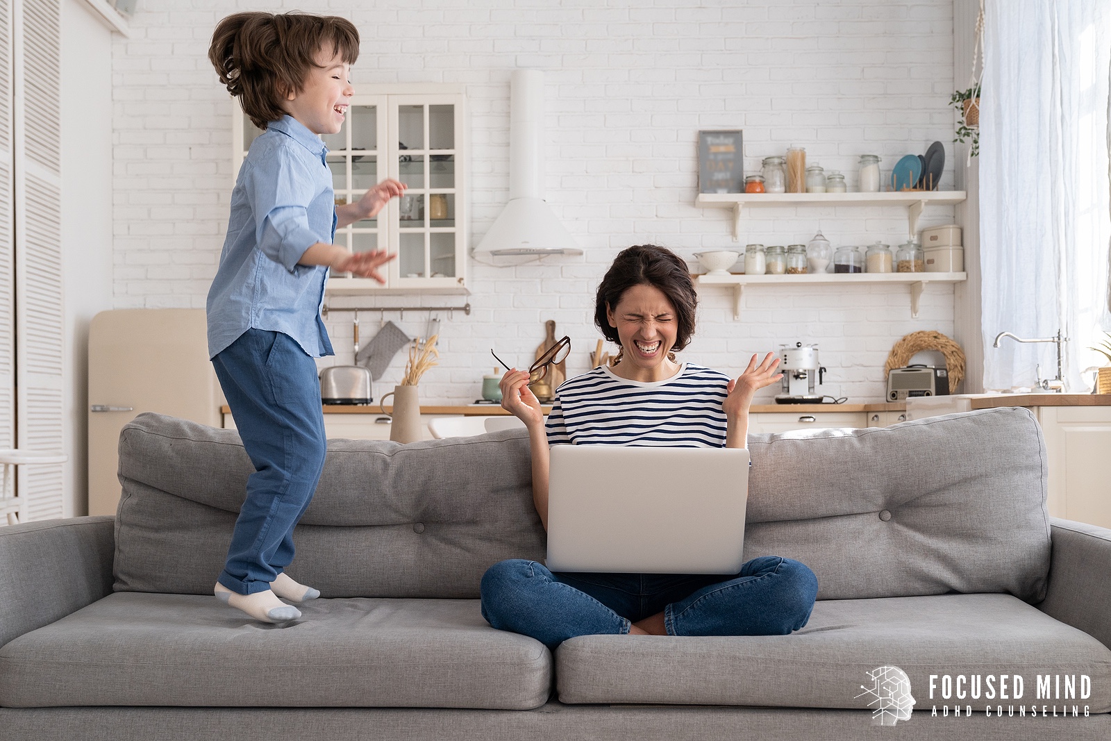 A mother closes her eyes while sitting on a sofa with as her child jumps and distracts her. Learn tips for addressing overwhelm by searching for an adult ADHD therapist in Columbus, OH. They can offer help with ADHD and overthinking today.