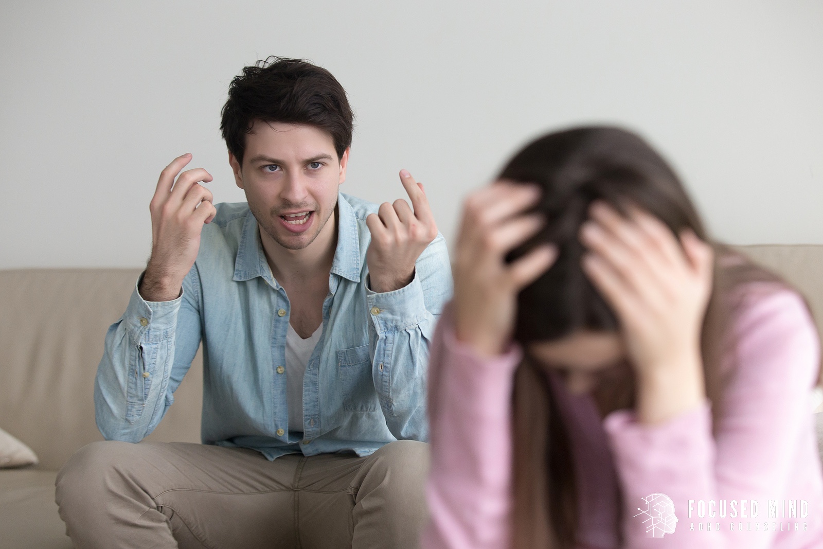 A couple struggling with conflict related to ADHD and emotional regulation sits on a couch during an argument, highlighting emotional dysregulation ADHD Columbus, OH, and the importance of emotional regulation therapy in Columbus, OH with an adult ADHD therapist in Ohio.