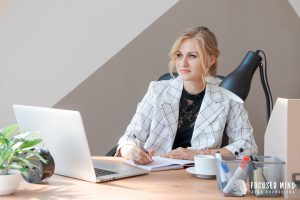 Thoughtful woman at a desk with a laptop and notebook – Illustrating decision fatigue from ADHD and overthinking, highlighting the benefits of ADHD therapy in Columbus, OH and online ADHD treatment in Columbus, OH.