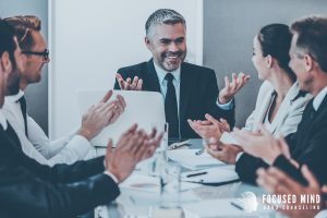 A businessman smiles confidently while colleagues applaud his success. This moment reflects how adult ADHD treatment in Columbus, OH can empower professionals. With the help of an adult ADHD therapist in Columbus, OH and an ADHD specialist in Columbus, OH, adults can thrive in the workplace.