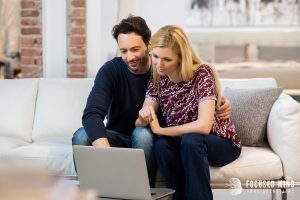 A couple sits together on a couch looking at a laptop, highlighting the benefits of online ADHD treatment in Columbus, OH, while also reflecting guidance from a couples therapist in Columbus, OH and ADHD couples therapist in Columbus, OH.