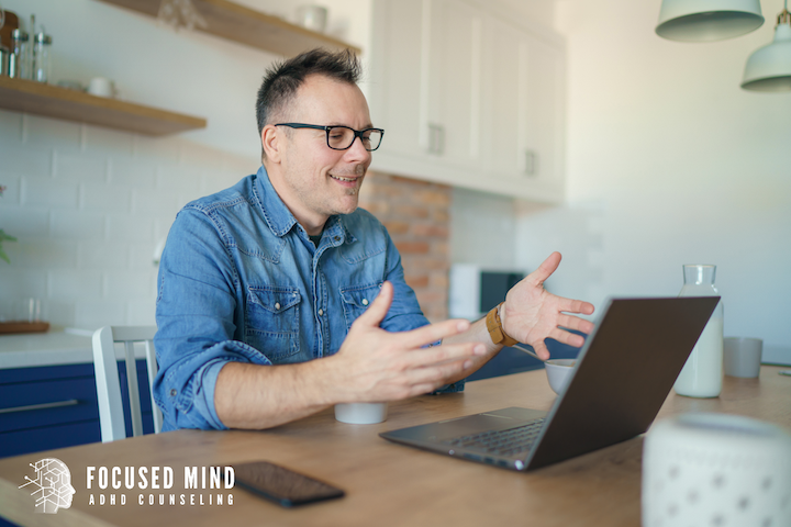 A man gestures animatedly during a video call, clearly engaged in conversation. Are you unsure whether you should get diagnosed with ADHD to understand long-standing attention struggles? An online ADHD therapist in Cincinnati, OH, can guide you toward clarity and next steps.