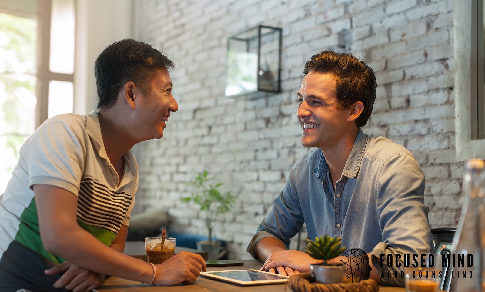 Two men sit at a cafe table engaged in conversation. When ADHD impacts your marriage, does genuine connection feel harder to maintain? An online ADHD therapist in Cincinnati, OH, teaches strategies to improve focus, listening skills, and presence in relationships.