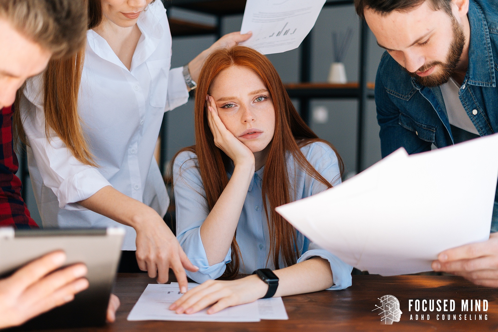 Overwhelmed employee in a meeting, showing how adhd symptoms ohio can lead to overcommitment and stress. Support from an adhd therapist in columbus, oh and an adhd evaluation in columbus, oh can help.