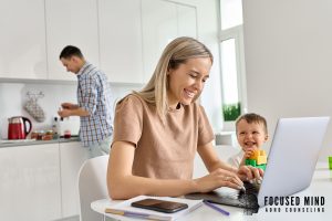 Parent working on a laptop while caring for a child at home, highlighting real-life work-life balance challenges and adhd symptoms ohio. An adhd evaluation in columbus, oh and online adhd treatment in columbus, oh with an adult adhd therapist in columbus, oh can help.