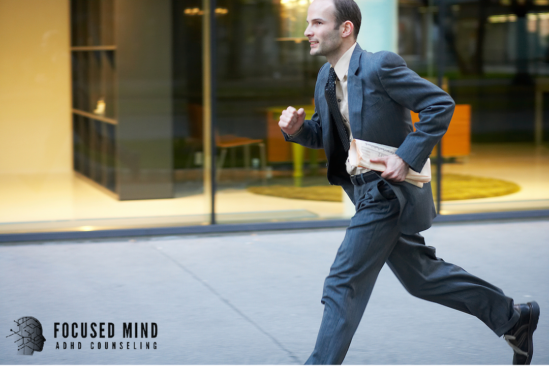A businessman in a suit sprints down a city sidewalk clutching papers under his arm. Time blindness often causes people with ADHD to chronically rush, run late, and feel perpetually behind. An ADHD specialist in Cleveland, OH can help you get ahead of the cycle.