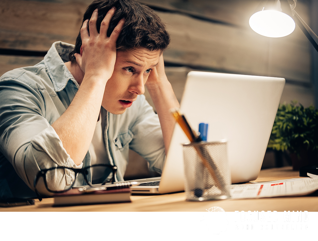 A man grips his head in distress while staring at his laptop. RSD can turn minor setbacks into intense emotional reactions that feel impossible to control. ADHD testing in Cleveland, OH, can help you understand what's really driving those responses.