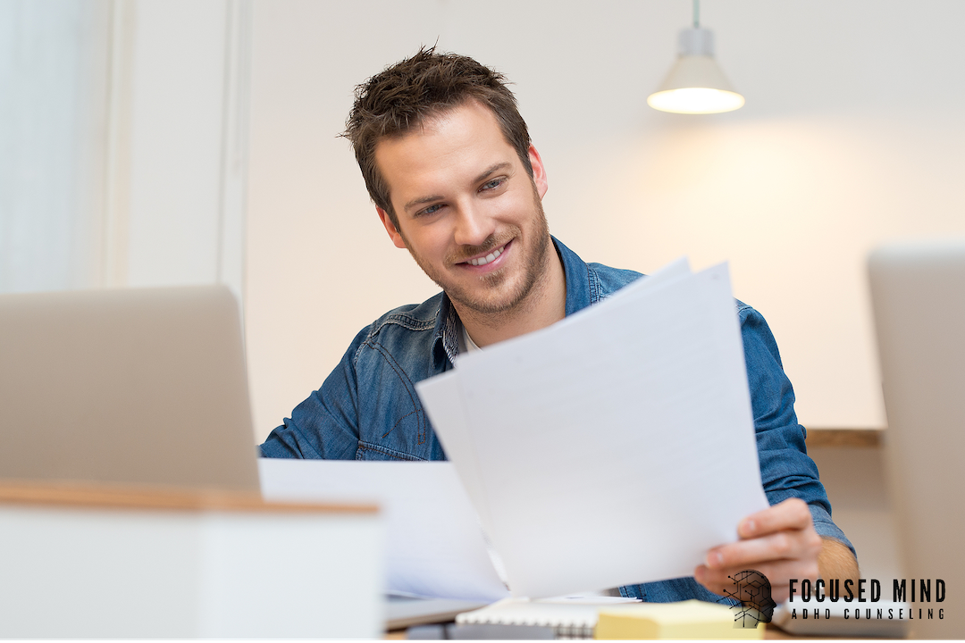 A smiling man in a denim shirt reviews documents at his desk with a laptop nearby. Finding motivation with ADHD can feel like a constant uphill battle in work and daily life. An ADHD specialist in Cincinnati, OH can help you get unstuck.