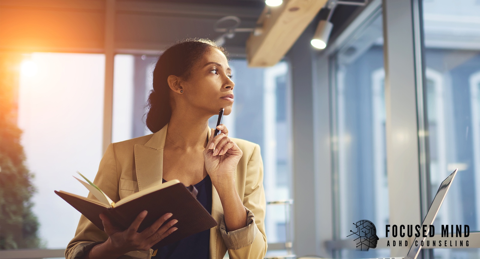 A professional woman holds a notebook and pen, gazing thoughtfully upward. Could rumination be the hidden way your ADHD shows up at work, keeping you stuck in your own head? An ADHD specialist in Cincinnati, OH, can help you break the cycle.