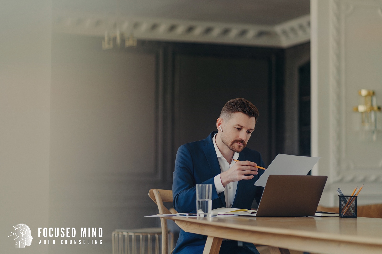 A businessman in a navy suit sits at a wooden desk. Does overwhelm make it nearly impossible to prioritize tasks? An ADHD specialist in Cleveland, OH can help you understand why busy seasons feel so much harder and what to do about it.
