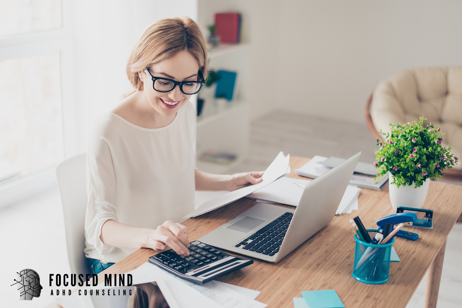 A smiling woman works at a bright, organized desk. Does ADHD make it difficult to stay on top of responsibilities? ADHD testing in Cleveland, OH can help uncover the patterns behind your struggles and point you toward lasting strategies for success.